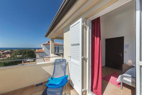 a blue chair sitting on a balcony with a window at Vila Bicikleta Istra in Peroj