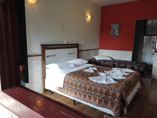 a hotel room with two beds with towels on them at Pousada Horto dos Contos in Ouro Preto