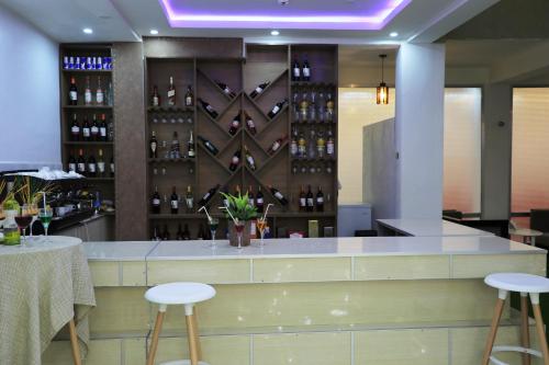 - un bar dans un restaurant avec deux tabourets et des bouteilles de vin dans l'établissement Riverland Hotel, à Baher Dar