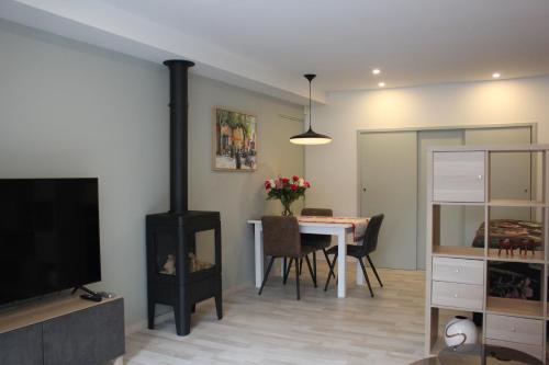 a living room with a fireplace and a dining room table at Appartement Dersaborg in Valkenburg