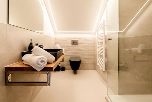 a bathroom with a sink and a shower with towels at Hotel auszeit Neunkirchen-Seelscheid in Neunkirchen
