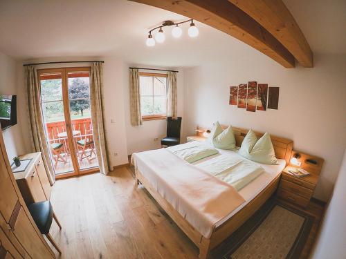 ein Schlafzimmer mit einem großen Bett und einem Balkon in der Unterkunft Appartements Macheiner in Mariapfarr