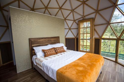 una camera con un grande letto in una stanza con finestre di Reserva del Dorado a Sesquilé