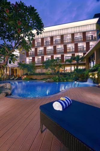 a hotel with a pool in front of a building at Aston Bojonegoro City Hotel in Bojonegoro