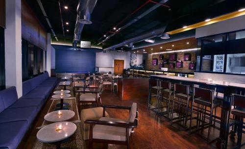 a restaurant with tables and chairs and a bar at Aston Bojonegoro City Hotel in Bojonegoro