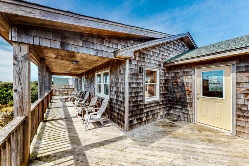 a house with a deck with chairs on it at Pirate's Light #73-B in Buxton