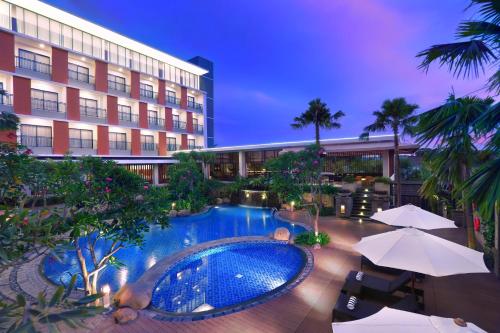 ASTON Bojonegoro City Hotel في Bojonegoro: فندق فيه مسبح امام مبنى