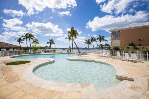 - une piscine avec des chaises et des palmiers dans un complexe dans l'établissement St Martin Nettlé Bay Lovely appartment, à Saint-Martin