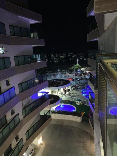 a large building with a swimming pool at night at apartamento de frente para o mar com linda area de lazer in Arraial do Cabo
