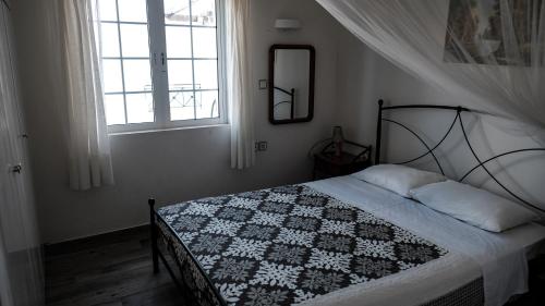 a bedroom with a bed with a black and white quilt at Evreti Villa with Stunning views, near Fiscardo in Fiskardho