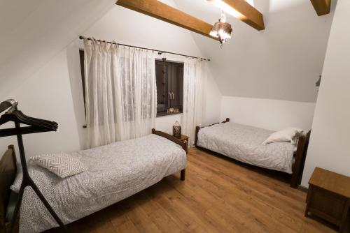 a bedroom with two beds and a window at Jodłowe Chaty in AdamÃ³w