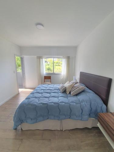 a bedroom with a large bed with a blue comforter at Departamento a estrenar con vista al río in Victoria