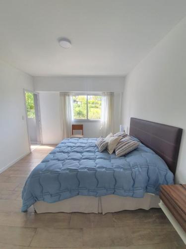 a bedroom with a large bed with a blue comforter at Departamento con vista al río in Victoria