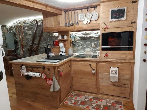 cocina con armarios de madera y horno con fogones en Maison du ski LTH - CIR -VDA-LA THUILE-N0011, en La Thuile