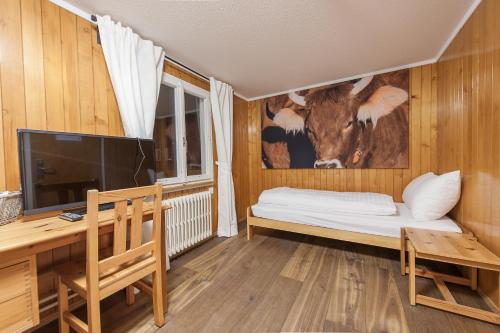 a bedroom with a cow mural on the wall at Hotel Kaiserstuhl in Lungern