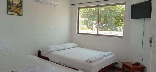 a room with two beds and a window at Ortimar in Tolú