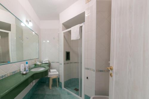 a bathroom with a sink and a mirror and a shower at Villa Bina Sea Hotel in Ischia