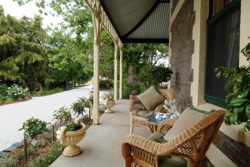 a porch with wicker chairs and a table on a house at The Lodge Country House in Marananga