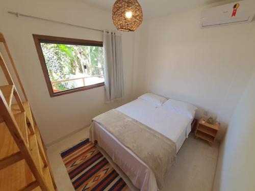 a small bedroom with a bed and a window at Vila Pitangueira - Apto Verde - No Centro de Serra Grande com Piscina, Jacuzzi, Internet Rápida in Serra Grande