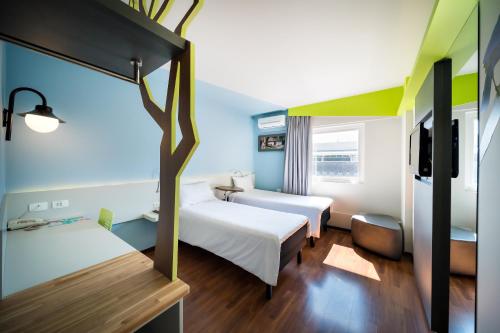 a hotel room with two beds and a tv at ibis Styles Curitiba Centro Civico in Curitiba