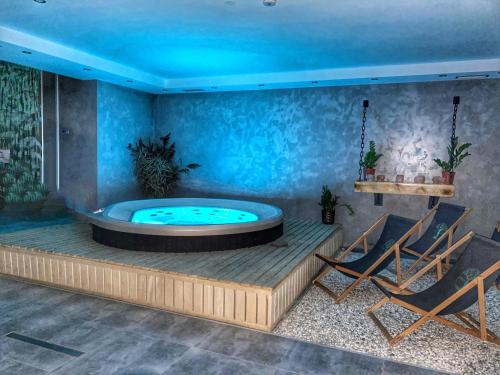 a hot tub in a room with two chairs at Dziejba Leśna Apartamenty &Spa - piękne i nowe apartamenty i domek, sauna i jacuzzi - W CENIE I NA WYLACZNOŚĆ, 1 km od stoku in Jaworki