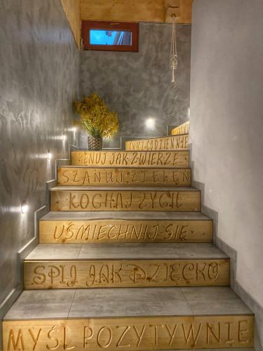 a set of stairs with writing on them at Dziejba Leśna Apartamenty &Spa - piękne i nowe apartamenty i domek, sauna i jacuzzi - W CENIE I NA WYLACZNOŚĆ, 1 km od stoku in Jaworki