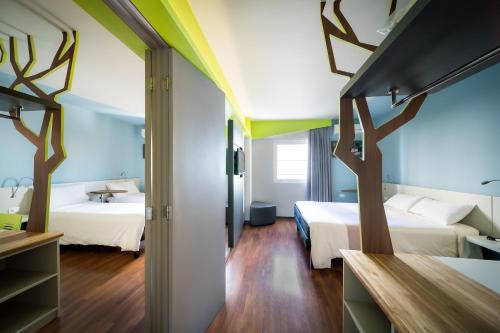 a hotel room with two beds and a hallway at ibis Styles Curitiba Centro Civico in Curitiba
