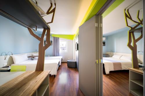 a hotel room with two beds and two trees at ibis Styles Curitiba Centro Civico in Curitiba