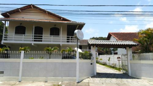 a house with a fence in front of it at Pousada Videira de Teresópolis in Teresópolis