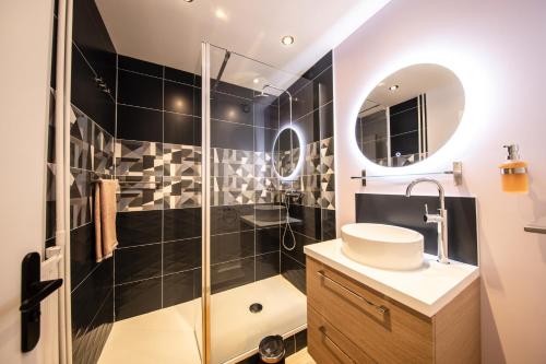 y baño con ducha y lavamanos. en Le petit Panam - Appartement privé de 45 m2 - 2 à 4 personnes - Parking privé, en Metz