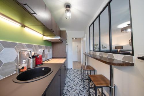 a bathroom with a sink and a counter with chairs at Le petit Panam - Appartement privé de 45 m2 - 2 à 4 personnes - Parking privé in Metz