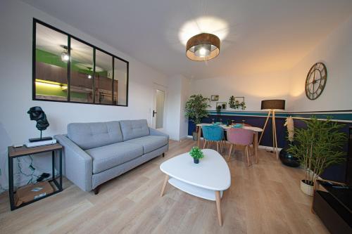 a living room with a couch and a table at Le petit Panam - Appartement privé de 45 m2 - 2 à 4 personnes - Parking privé in Metz
