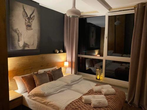 - une chambre avec un lit doté d'oreillers et d'une fenêtre dans l'établissement Apartament SPA 52 Resort Kozubnik blisko Szczyrk- 5D Apartamenty, à Porąbka