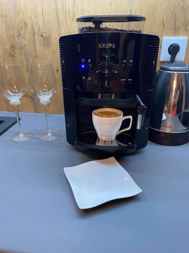 a coffee maker and two wine glasses on a table at Apartament SPA 52 Resort Kozubnik blisko Szczyrk- 5D Apartamenty in Porąbka