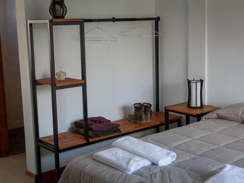 a room with a bed and a shelf with shoes at Tambo Aparts in El Calafate