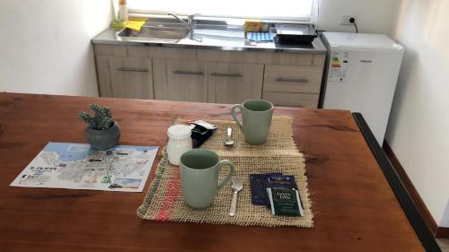 a table with three green cups on top of it at Tambo Aparts in El Calafate