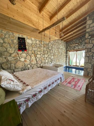 帕塔拉的住宿－Shavilla Kalkan - Yalı ' da Korunaklı 1+1 Villa，卧室配有一张石墙床