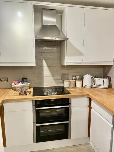 a kitchen with white cabinets and a stove top oven at Pottery Gate, Bowness-on-Windermere in Bowness-on-Windermere