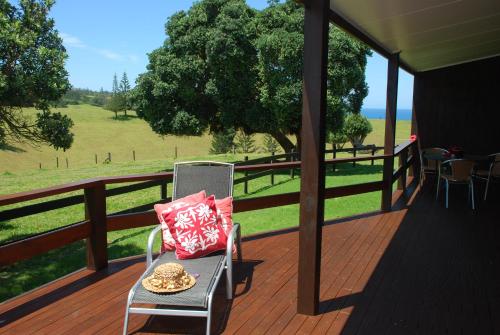 a chair on a deck with a view of a field at Coast Norfolk Island in Burnt Pine