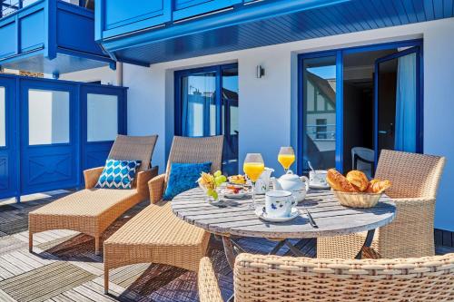 - une table et des chaises sur une terrasse avec une table et des boissons dans l'établissement Best Western Alexandra, à Saint-Malo