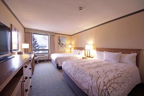 a hotel room with two beds and a television at The Water Tower Inn - BW Premier Collection in Sault Ste. Marie