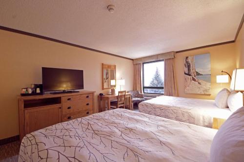 a hotel room with two beds and a flat screen tv at The Water Tower Inn - BW Premier Collection in Sault Ste. Marie