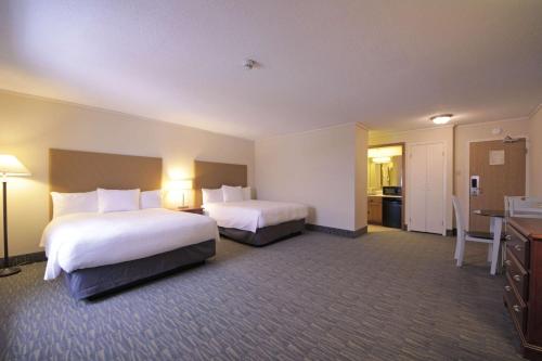 a hotel room with two beds and a kitchen at The Water Tower Inn - BW Premier Collection in Sault Ste. Marie