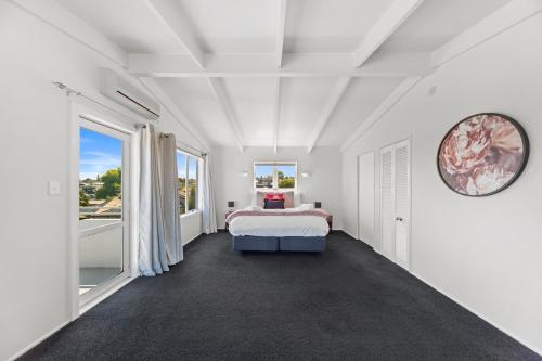 um quarto com uma cama e uma grande janela em Hilltop House - Taupo em Taupo