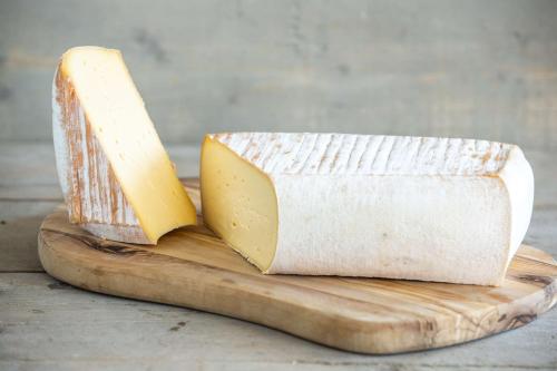 a block of cheese on a wooden cutting board at Radisson Blu Hotel, Antwerp City Centre in Antwerp