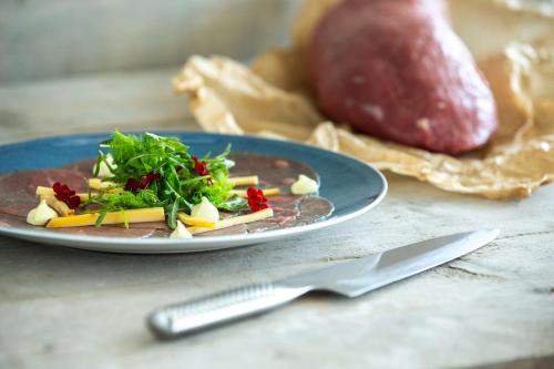 a plate of food on a table with a fork and knife at Radisson Blu Hotel, Antwerp City Centre in Antwerp