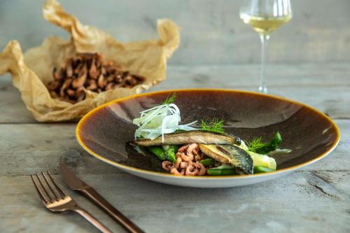 a plate of food with vegetables and a glass of wine at Radisson Blu Hotel, Antwerp City Centre in Antwerp
