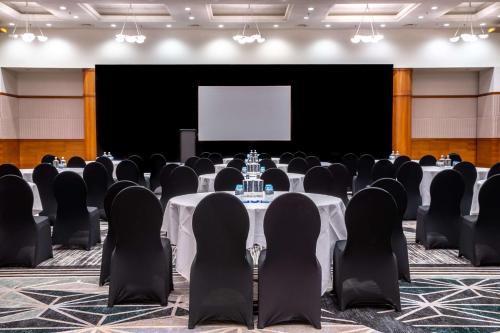 a conference room with tables and chairs and a screen at Radisson Blu Hotel, Antwerp City Centre in Antwerp