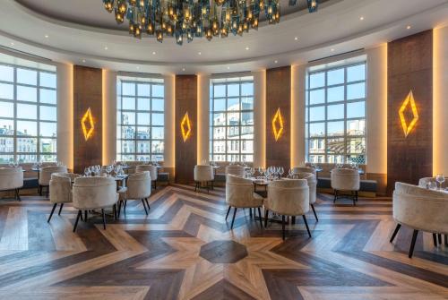 a dining room with tables and chairs and windows at Radisson Blu Hotel, Antwerp City Centre in Antwerp