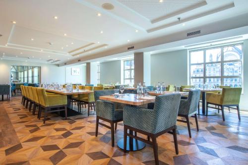 a restaurant with tables and chairs in a room at Radisson Blu Hotel, Antwerp City Centre in Antwerp